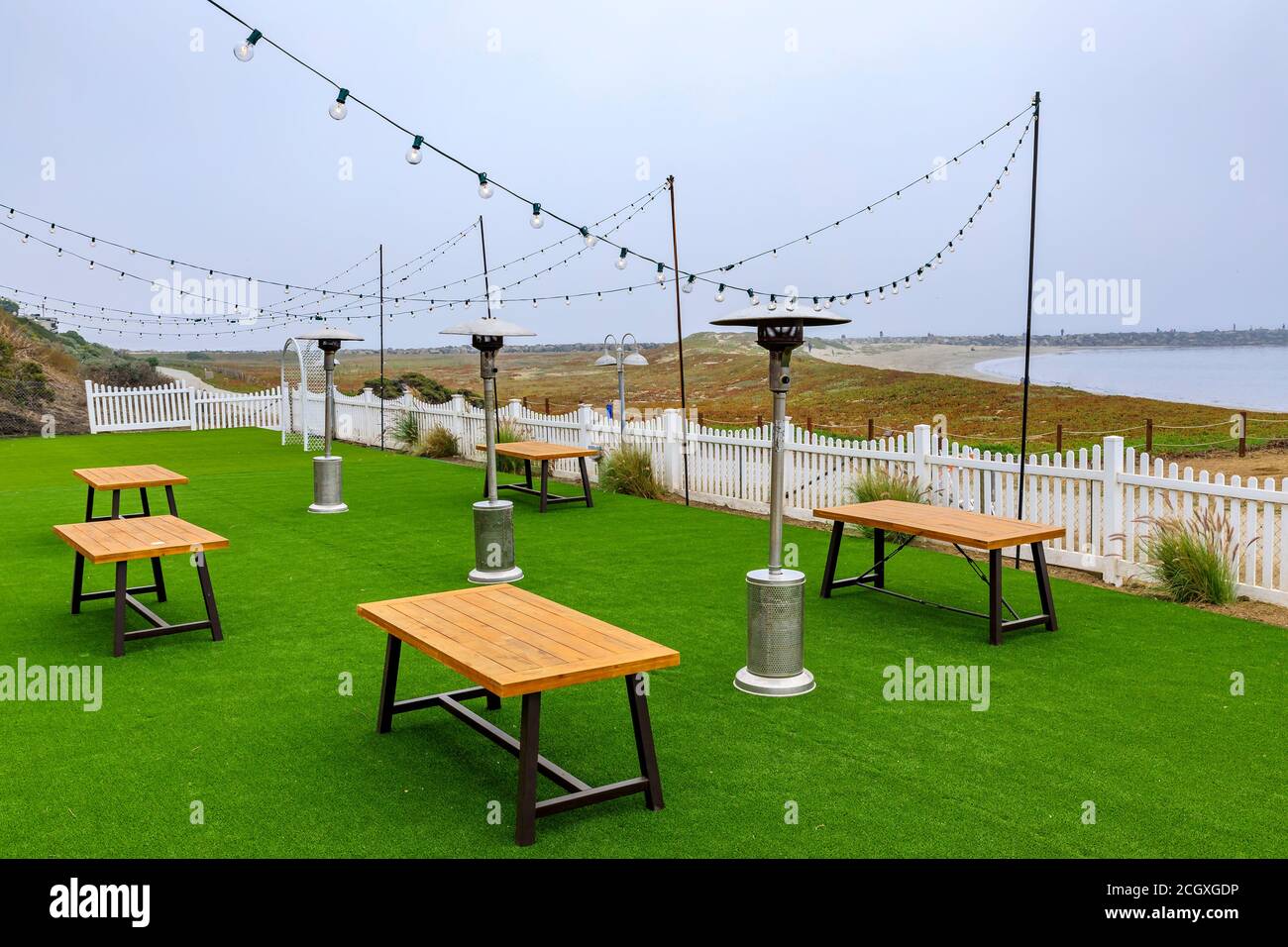 Places assises en plein air dans un restaurant en bord de mer vide en raison de la pandémie, Half Moon Bay près de San Francisco, Océan Pacifique en arrière-plan lors d'une journée brumeuse Banque D'Images