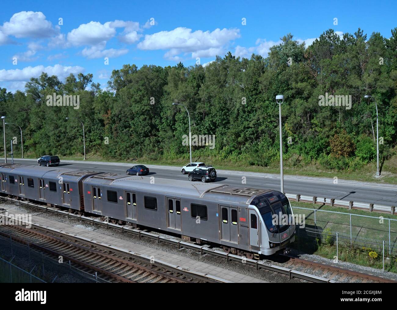 Toronto, Canada - le 4 septembre 2020 : l'un des trains de banlieue de Toronto circule en partie sous terre et en partie au-dessus du sol, à côté d'une autoroute. Banque D'Images