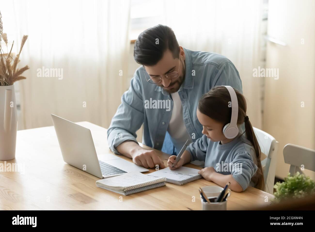 Papa aide petite fille de 7s vieux de préparer des devoirs. Banque D'Images