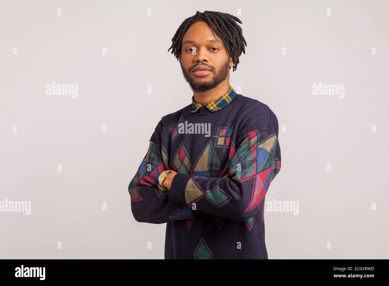 Homme africain concentré avec des dreadlocks sérieusement et professionnellement regardant la caméra, l'assurance. Prise de vue en studio isolée sur fond gris Banque D'Images