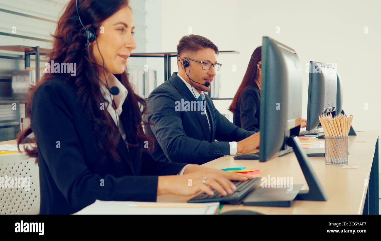 Les professionnels portant un micro-casque travaillant au bureau pour aider les clients ou collègues distants. Centre d'appels, télémarketing, agent d'assistance clientèle fournissent un service de vidéoconférence par téléphone. Banque D'Images