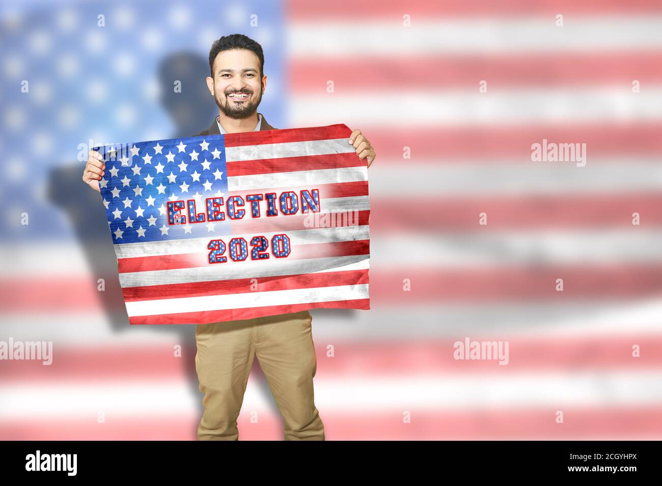 Jeune homme heureux tenant le drapeau national américain avec le sourire sur son visage, le concept de l'élection présidentielle de 2020, copier l'espace pour écrire du texte. Banque D'Images