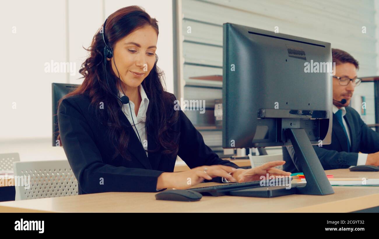 Les professionnels portant un micro-casque travaillant au bureau pour aider les clients ou collègues distants. Centre d'appels, télémarketing, agent d'assistance clientèle fournissent un service de vidéoconférence par téléphone. Banque D'Images