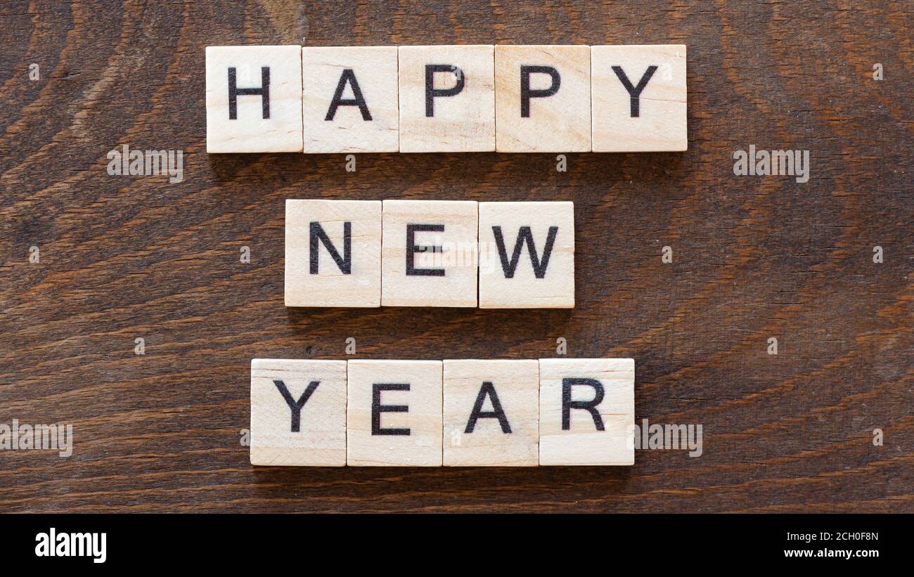 écrit « happy year » avec des lettres en bois clair dans le noir bois Banque D'Images