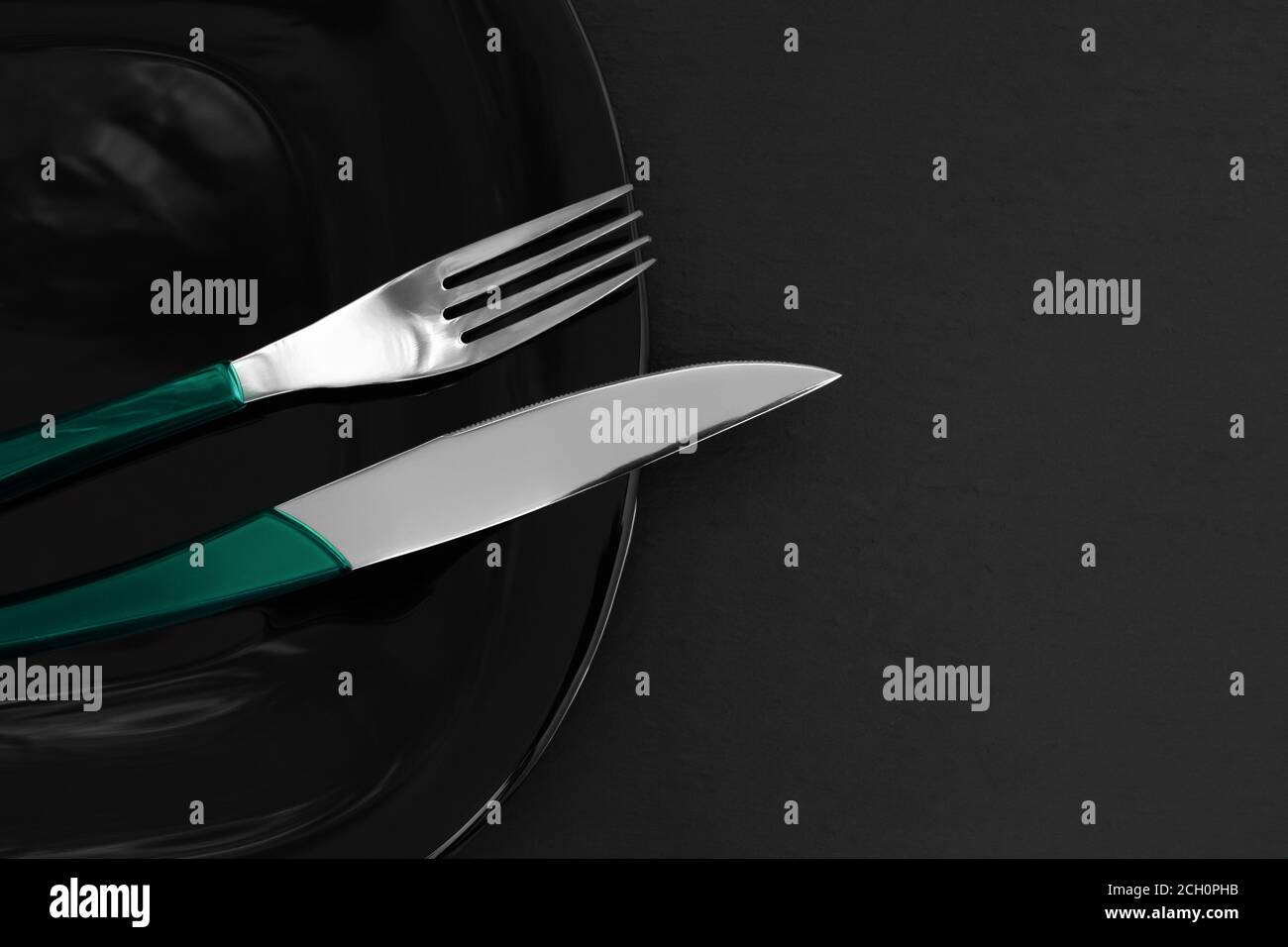 Vider l'assiette en ardoise noire, les couverts sur la table et la serviette en pierre sombre. Fond de nourriture pour le menu, recette. Réglage de la barre de coupe. Mise à plat, vue de dessus. Concept moderne SH Banque D'Images