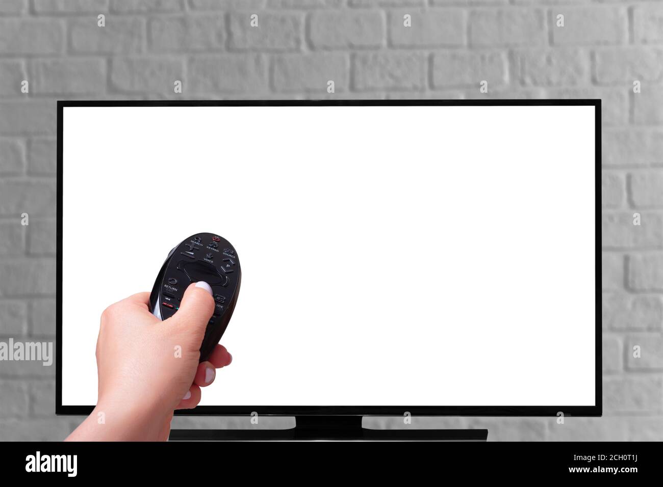 Main avec un téléviseur avec télécommande. Isolé sur fond blanc. Concept de streaming multimédia Banque D'Images