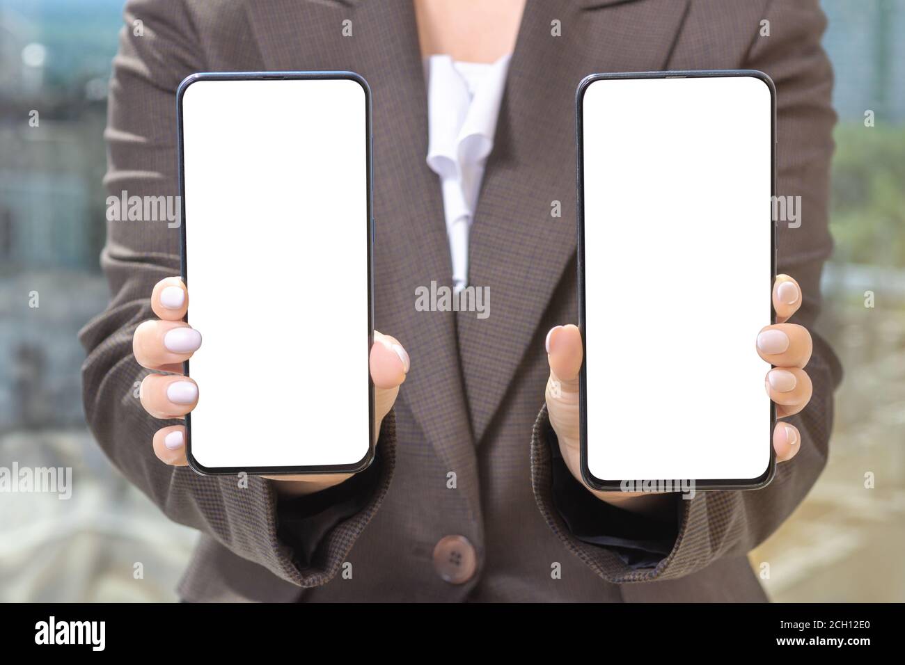 Mockup téléphone portable. Femme d'affaires en costume montre deux téléphones. Banque D'Images