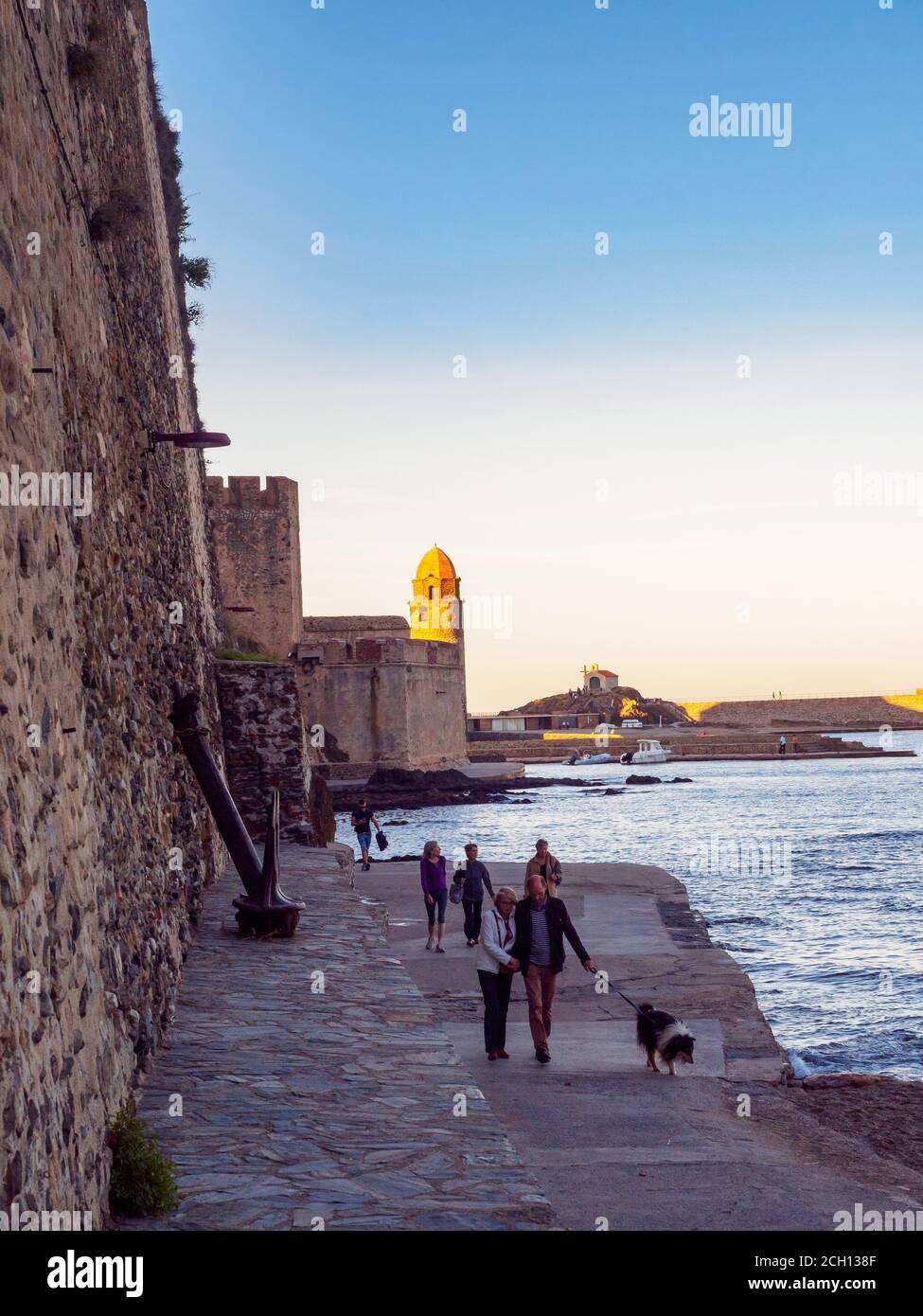 Couples qui prennent une promenade le soir le long du port, Collioure, Côte Vermeille, France Banque D'Images