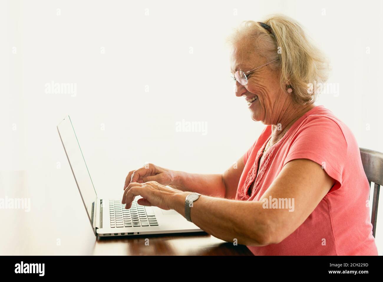 Femme âgée utilisant un ordinateur portable et ayant une conversation en ligne Banque D'Images