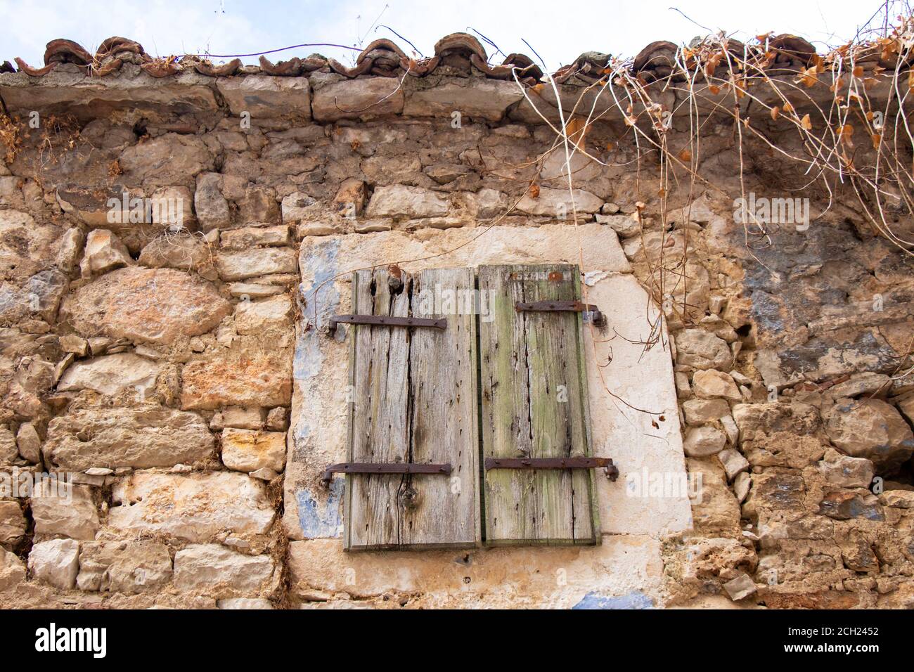 Fenêtre avec volets en bois fermés sur une ancienne maison en pierre traditionnelle abandonnée à Dalmatie, Croatie Banque D'Images