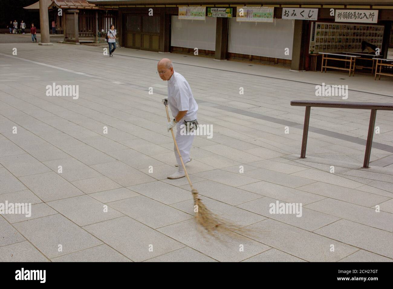 Harajuku, Tokyo / Japon - 16 juin 2018 : un vieil homme balaie le terrain du temple Meiji-jingu avec un balai de paille ou d'herbe. Banque D'Images