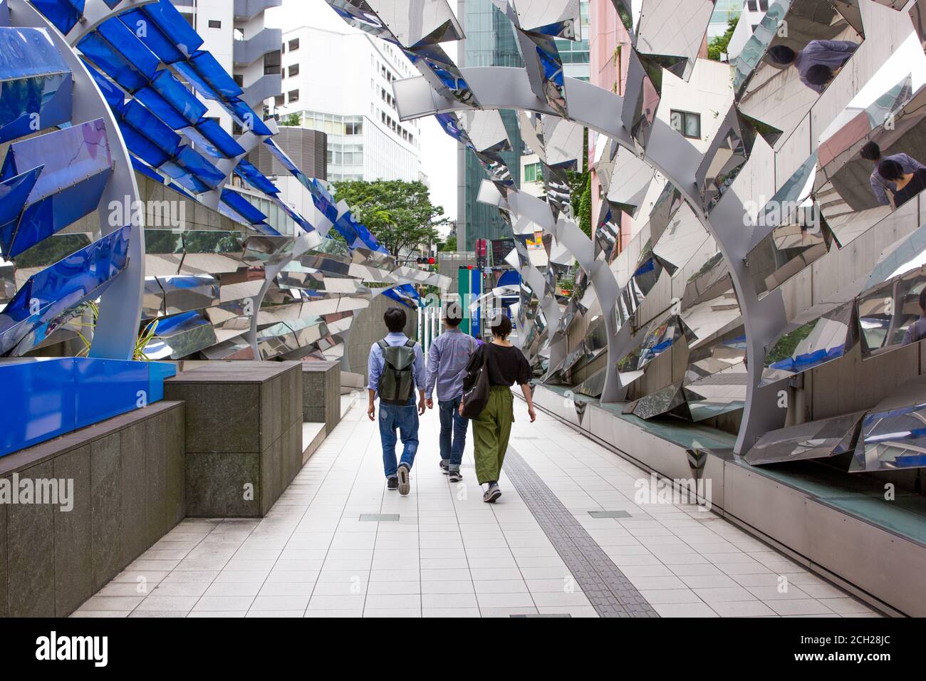 Shibuya, Tokyo / Japon - juin 2018 : trois jeunes Japonais marchent dans un tunnel unique qui sort d'un grand centre commercial. Banque D'Images