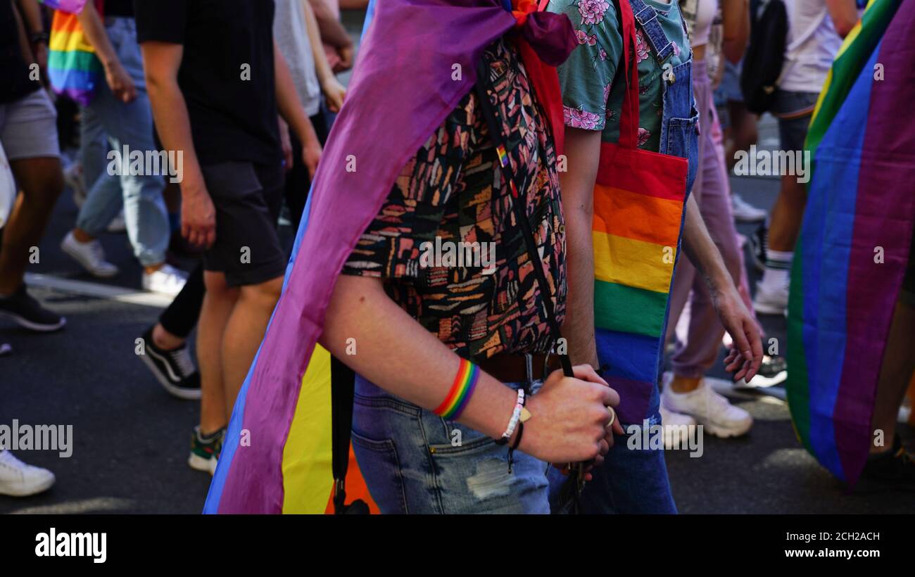 La marche de l'égalité LGBT. Deux gays tenant des mains marchant fierté parade. Les jeunes portant des vêtements et des symboles arc-en-ciel luttent pour les droits LGBTQ+. Banque D'Images