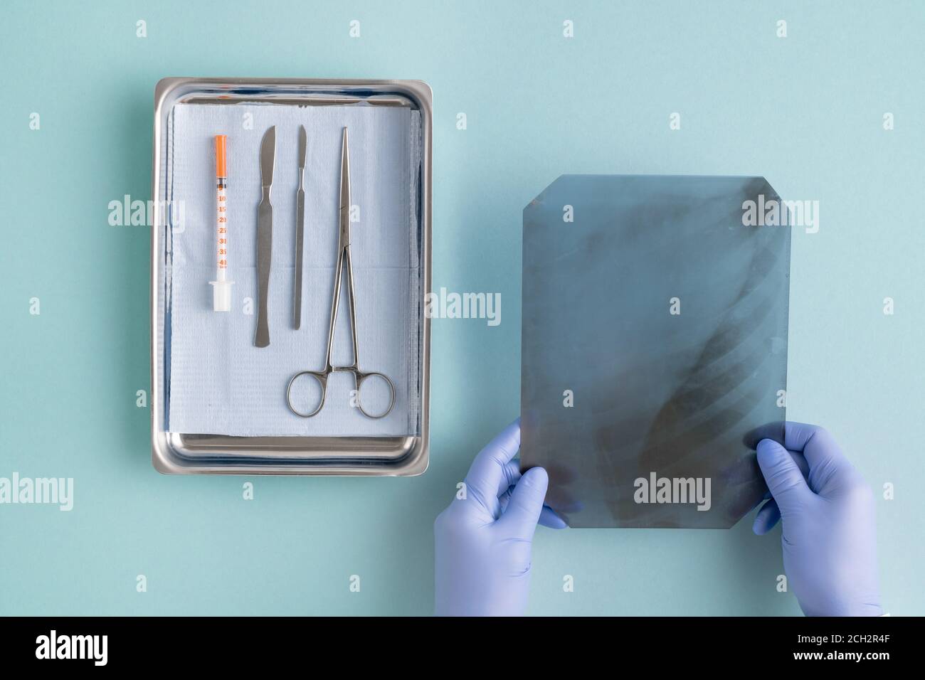 Vue des mains gantées du chirurgien qui a placé l'image radiographique instruments médicaux Banque D'Images