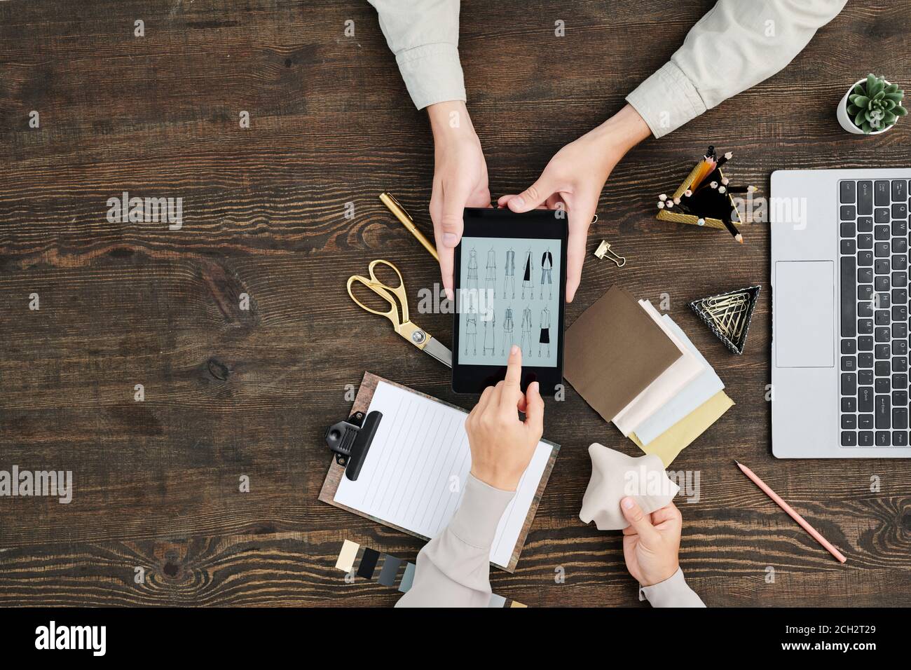 Mise à plat des mains créateur concepteur pointant vers les esquisses affichées de la tablette Banque D'Images