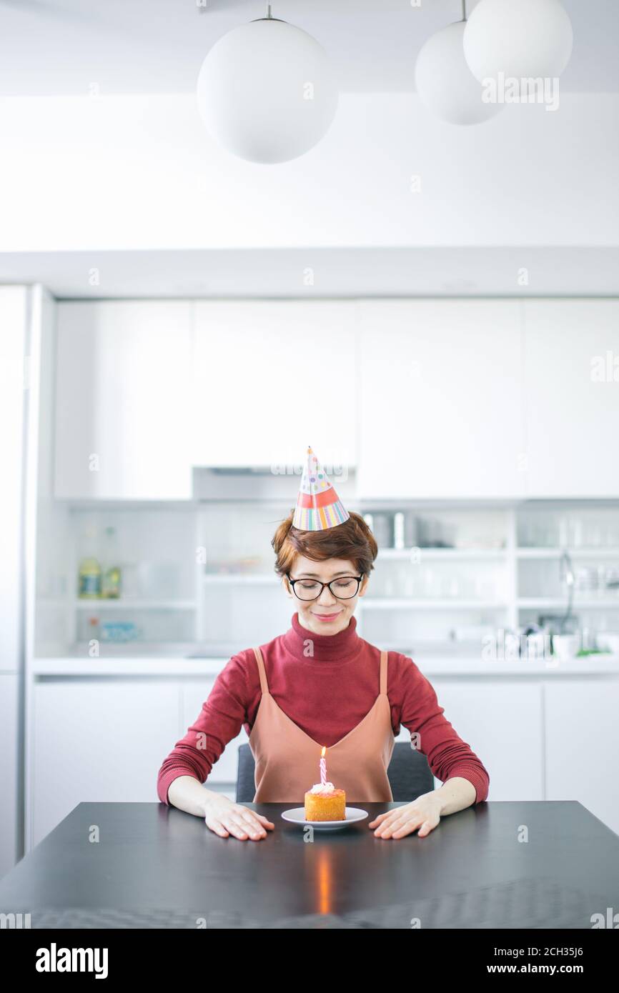 gros plan de la belle femme regardant la crêpe avec bougie à la maison.  célébrant l'anniversaire sans amis. concept de solitude Photo Stock - Alamy