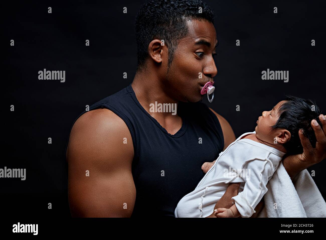 père africain essayant de faire rire son bébé. jeune père non expérimenté jouant avec son fils bébé. vue de près portrait.playful humeur Banque D'Images