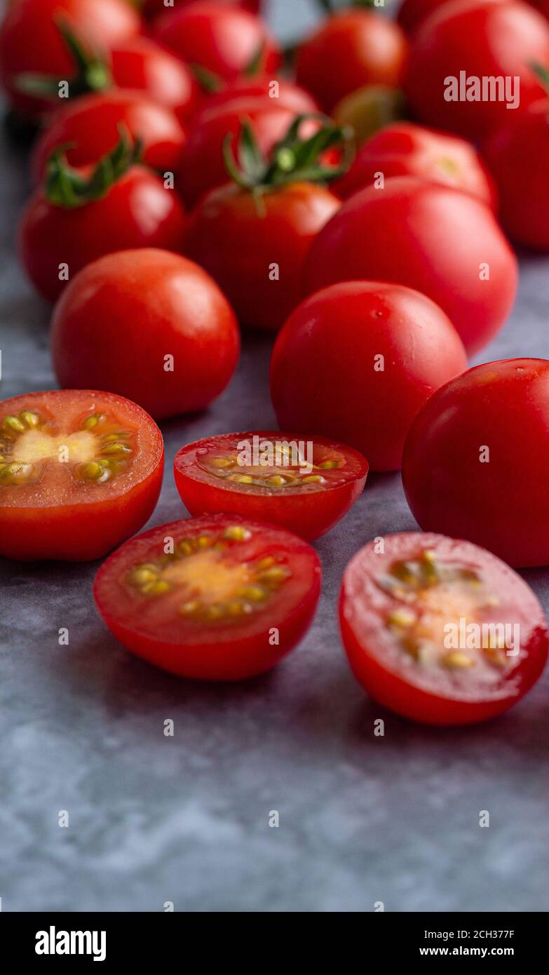 Tomates cerises avec un peu de fruits coupés Banque D'Images