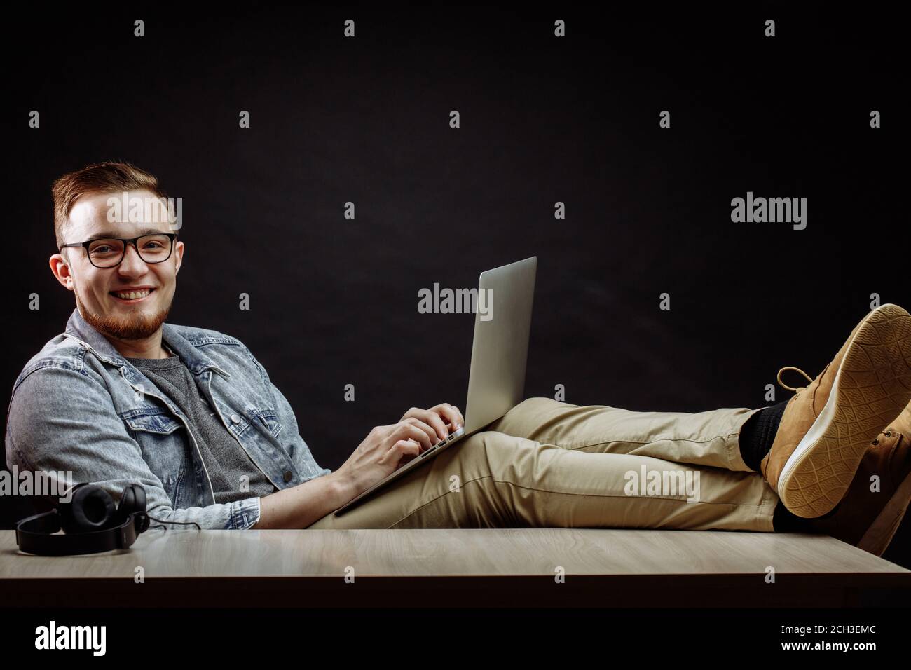 Close up portrait of happy woman in casual clothers élégant en utilisant le Net au travail et assis les jambes croisées Banque D'Images