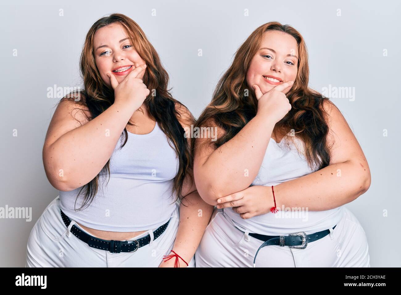 Plus taille caucasienne s urs femme portant des vetements blancs decontractes regardant avec confiance la camera sourire avec les bras croises et la main levee sur le menton. Fin Photo Stock Alamy
