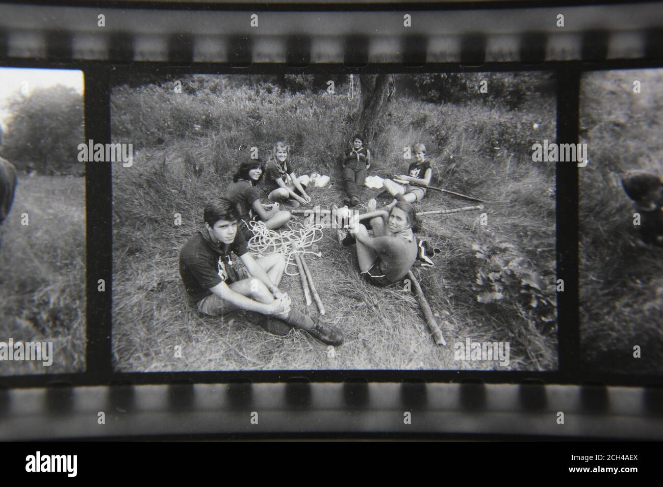 Fin 70s vintage photographie noir et blanc des scouts apprenant une activité à l'extérieur tout en campant au camp de scouts. Banque D'Images