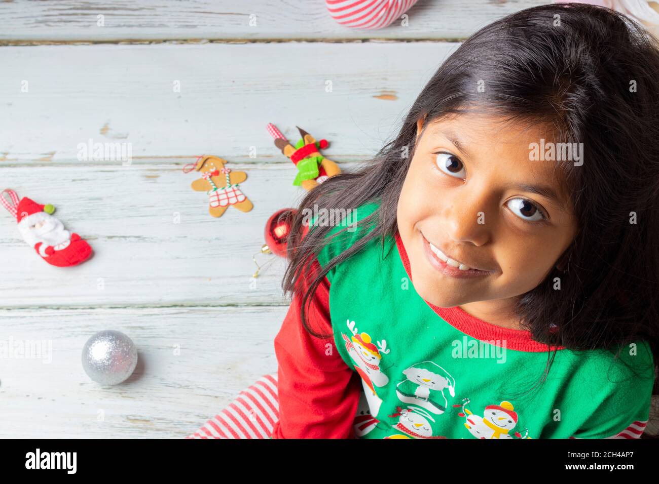 Cute brunette girl with Christmas pyjama smiling Banque D'Images