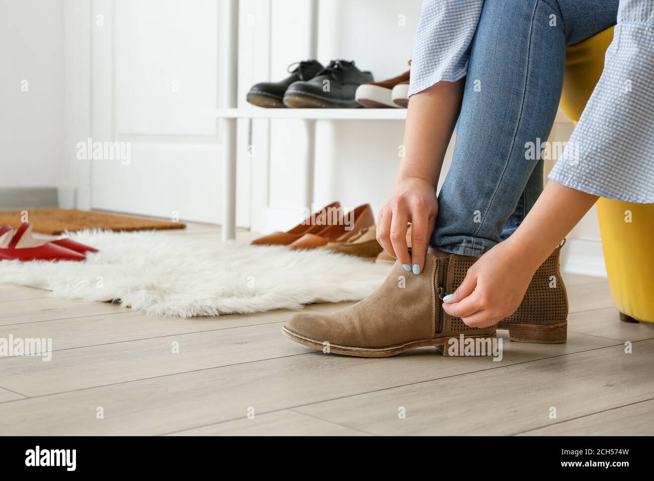 Femme qui met des chaussures élégantes dans le hall Photo Stock - Alamy
