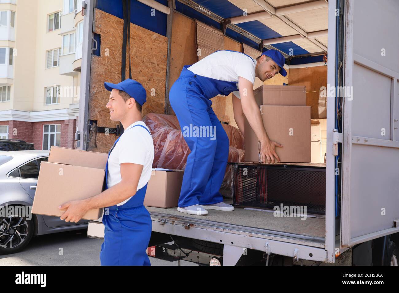 Chargeurs prenant le fret du camion Banque D'Images