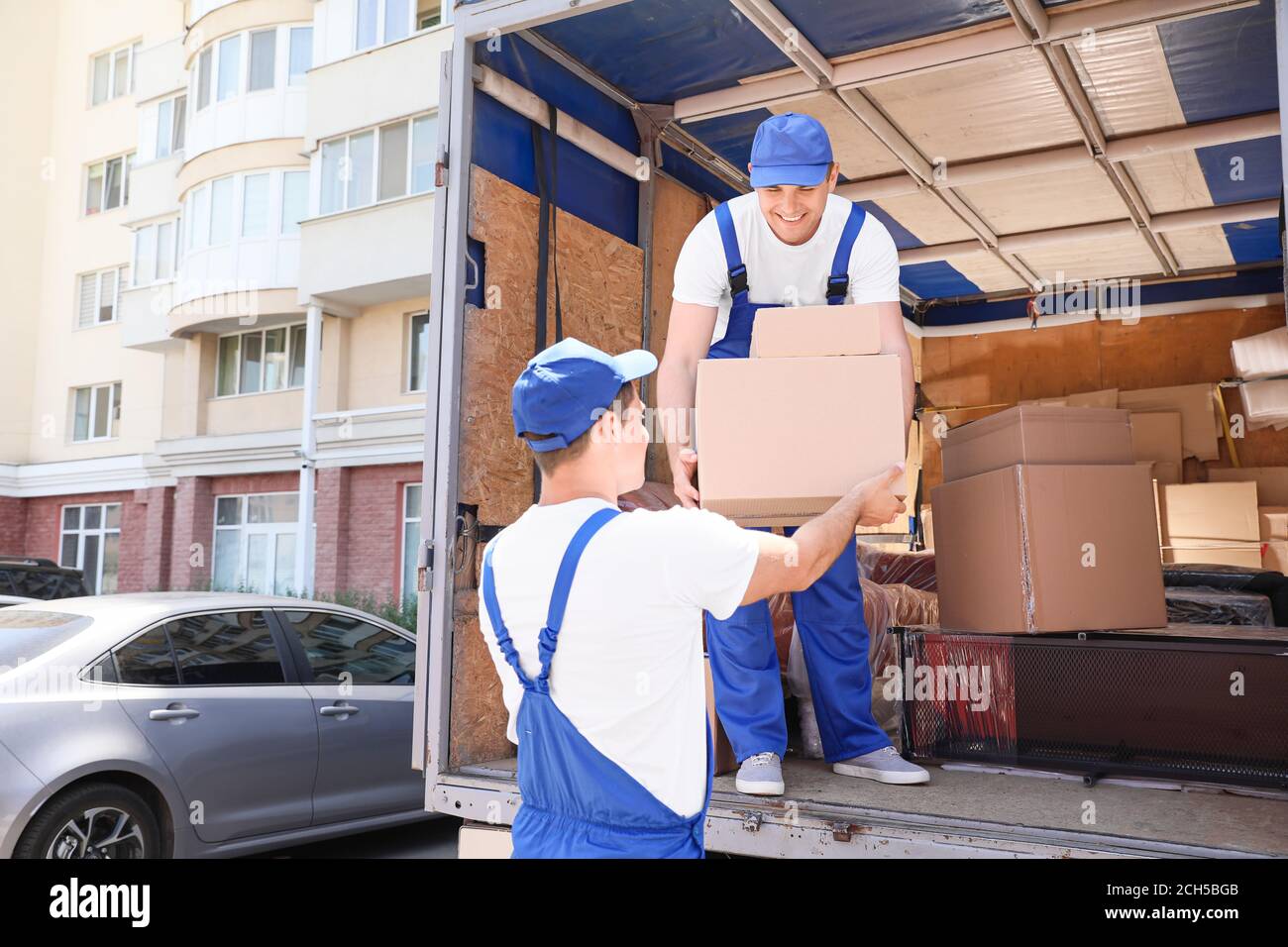 Chargeurs prenant le fret du camion Banque D'Images