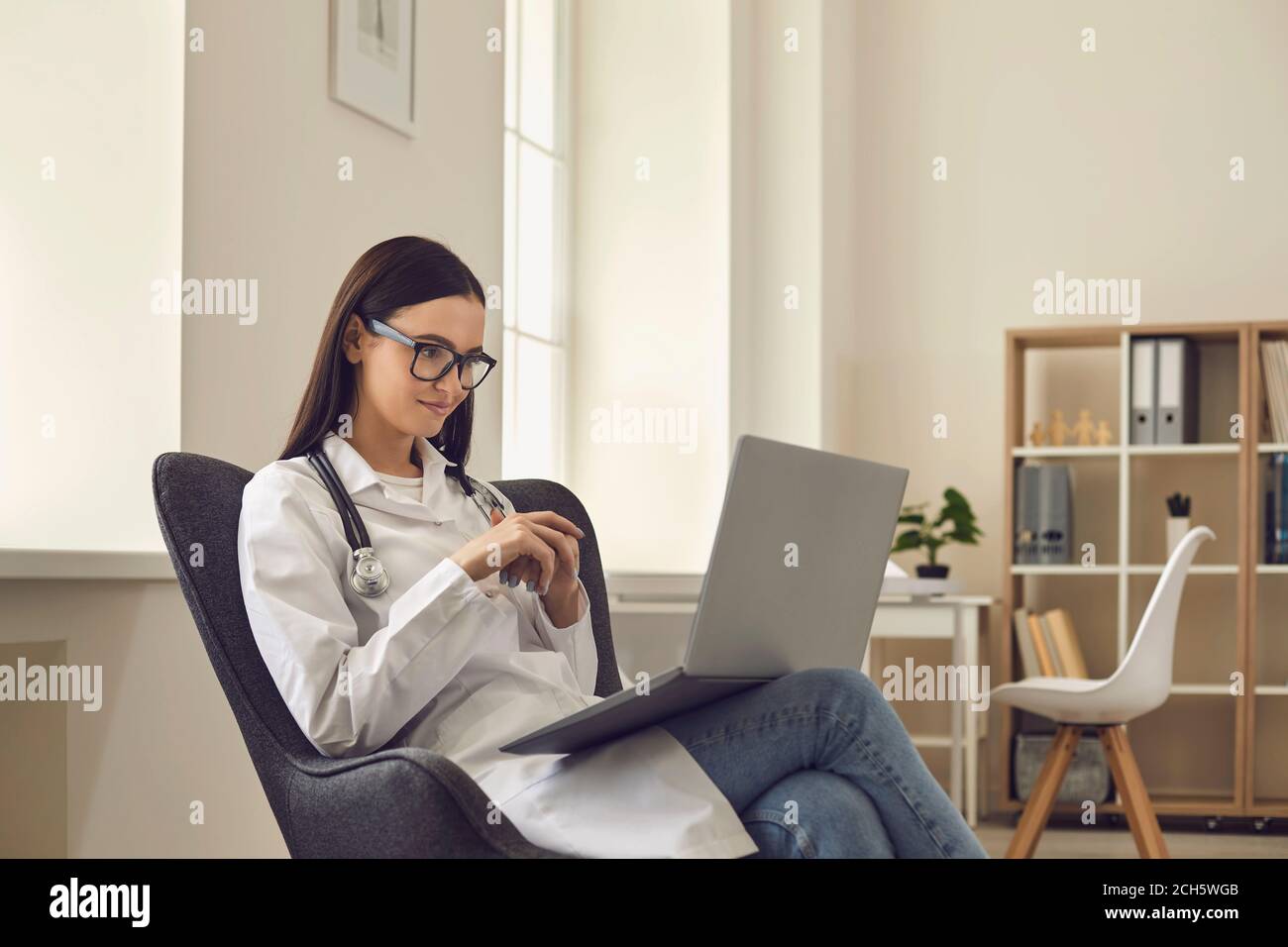 Une femme médecin consulte un patient en ligne par le biais d'un appel vidéo lorsqu'elle est assise au bureau. Banque D'Images