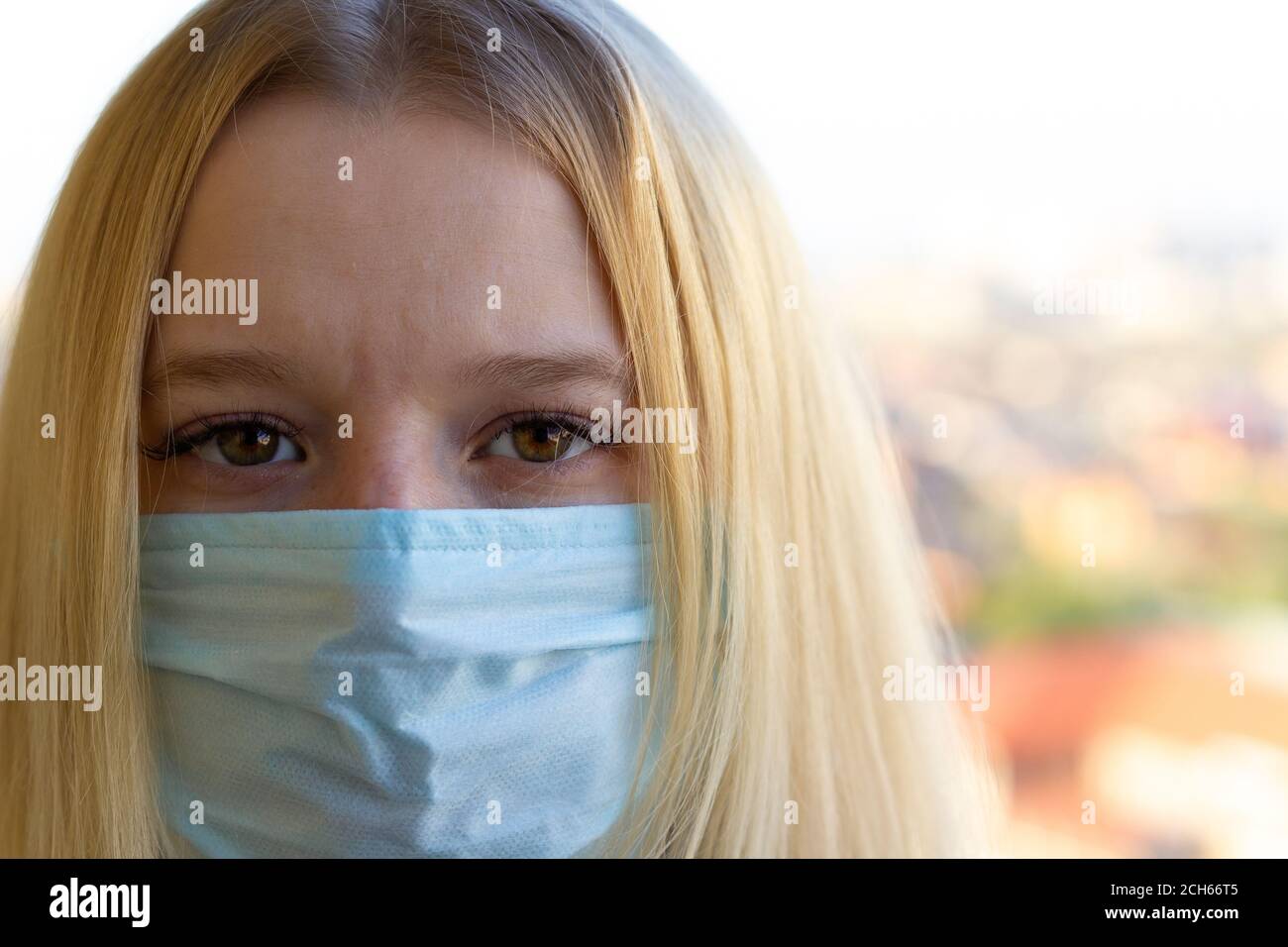 Portrait de jeune femme avec masque médical, fond de ville flou. Concept pendant la prévention du covid-19 pandémie mondiale de coronavirus. Banque D'Images
