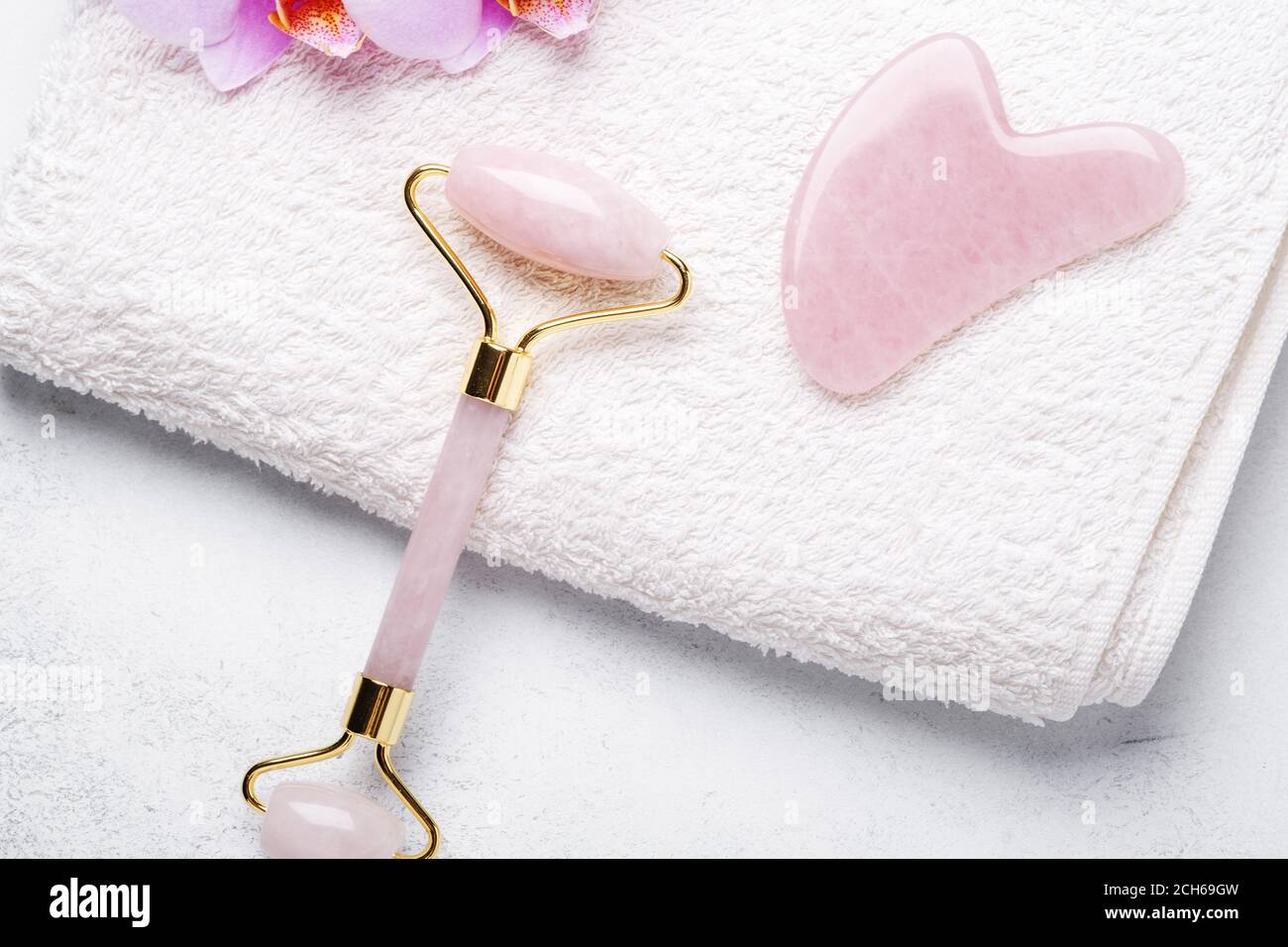 Masseur Gua Sha et rouleau facial sur fond de pierre. Traitement anti-âge, levage et virage - image Banque D'Images