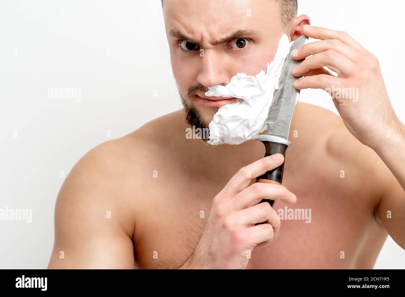 Jeune homme du caucase se raser la barbe avec un couteau sur fond blanc  Photo Stock - Alamy