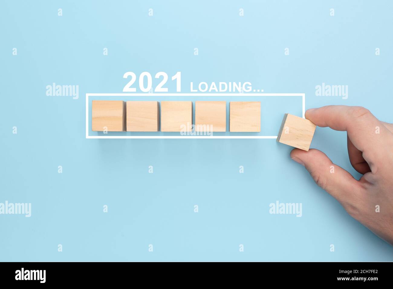 Chargement de la nouvelle année 2021 avec le cube de bois de mise à la main dans la barre de progression. Fond créatif pour la nouvelle année. Chargement du nouveau concept de l'an 2021 Banque D'Images