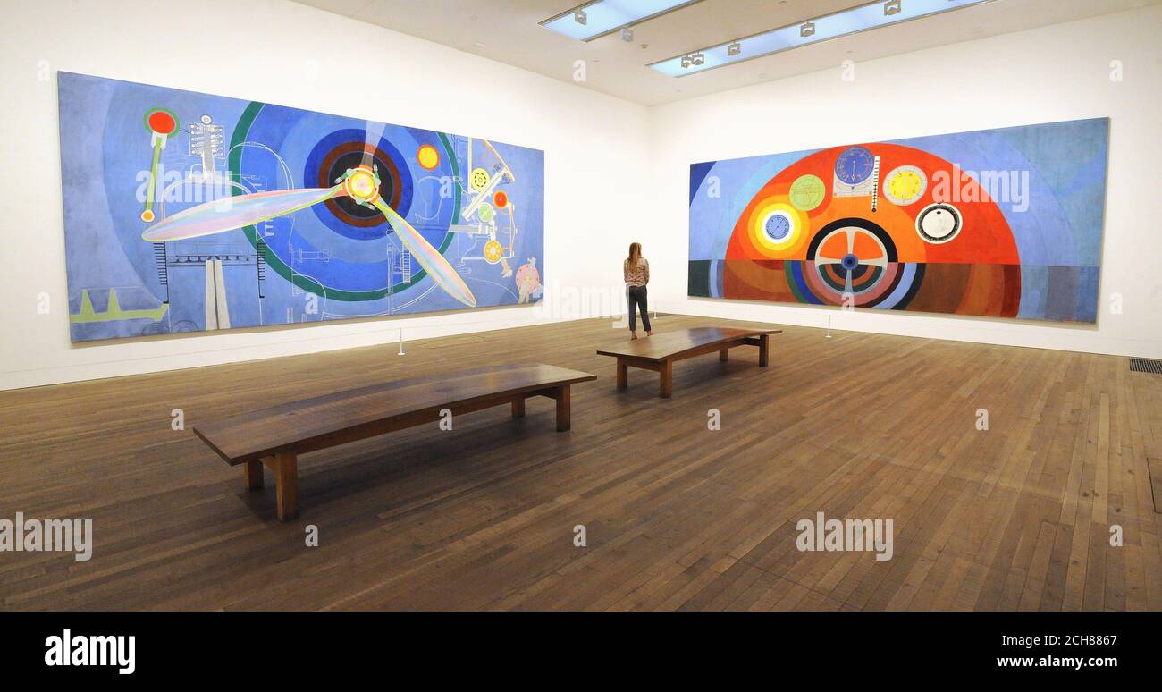 Un employé de Tate Modern regarde Propeller (à gauche, Air Pavillion) et Dashboard (Air Pavillion), par l'artiste Sonia Delaunay, qui fait partie de l'exposition EY: Sonia Delaunay au Tate Modern à Londres. Banque D'Images