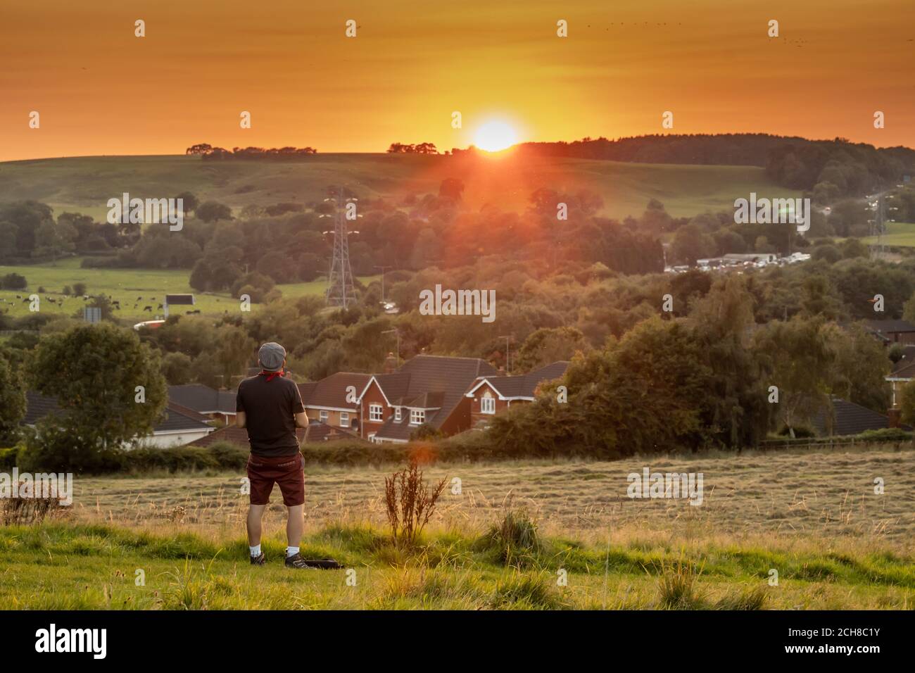 Un jeune homme profite du coucher de soleil sur la campagne anglaise Dans le Staffordshire Banque D'Images