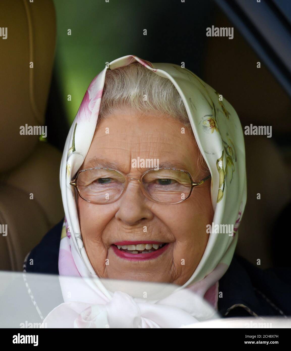 La reine Elizabeth II regarde par la fenêtre de sa voiture, alors qu'elle assiste au quatrième jour du Royal Windsor Horse Show, qui se tient dans le domaine du château de Windsor dans le Berkshire. Banque D'Images