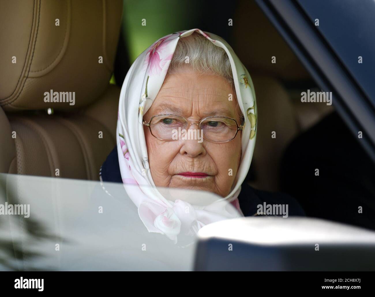 La reine Elizabeth II regarde par la fenêtre de sa voiture, alors qu'elle assiste au quatrième jour du Royal Windsor Horse Show, qui se tient dans le domaine du château de Windsor dans le Berkshire. Banque D'Images