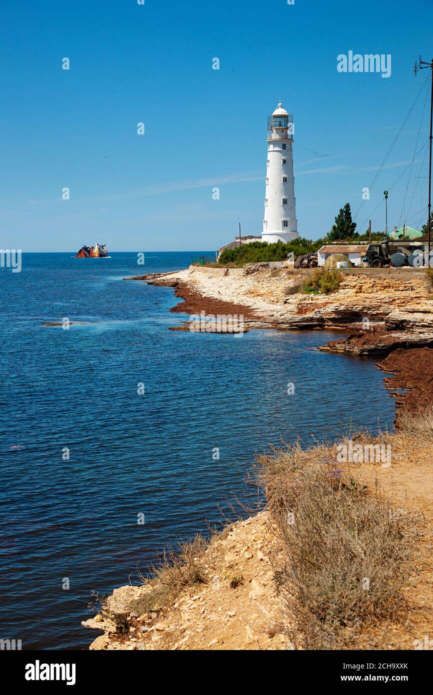 Paysage bleu de mer avec phare blanc sur la forêt Banque D'Images