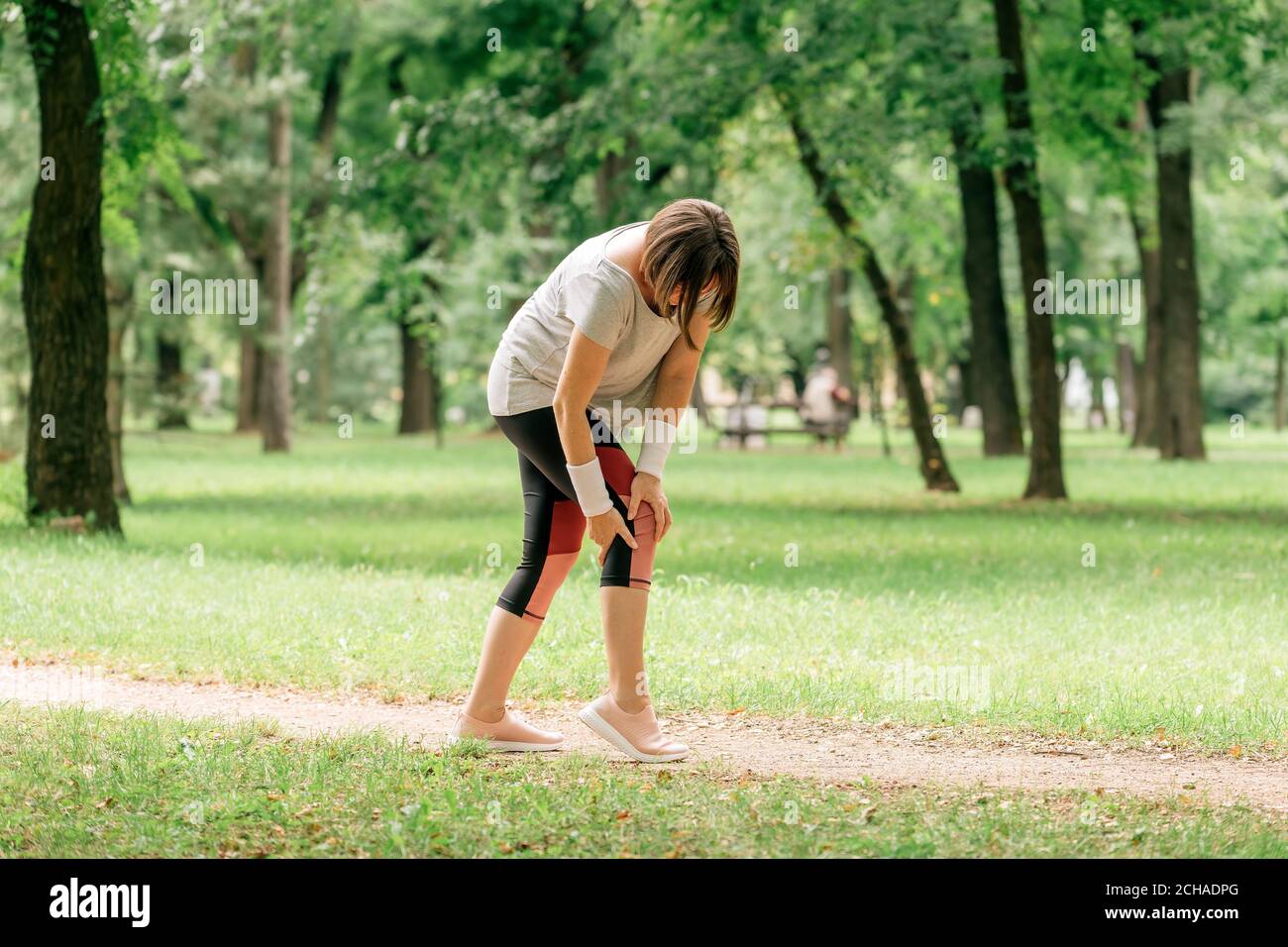 Jogging féminin avec blessure douloureuse au genou pendant l'activité de jogging du parc, concentration sélective Banque D'Images