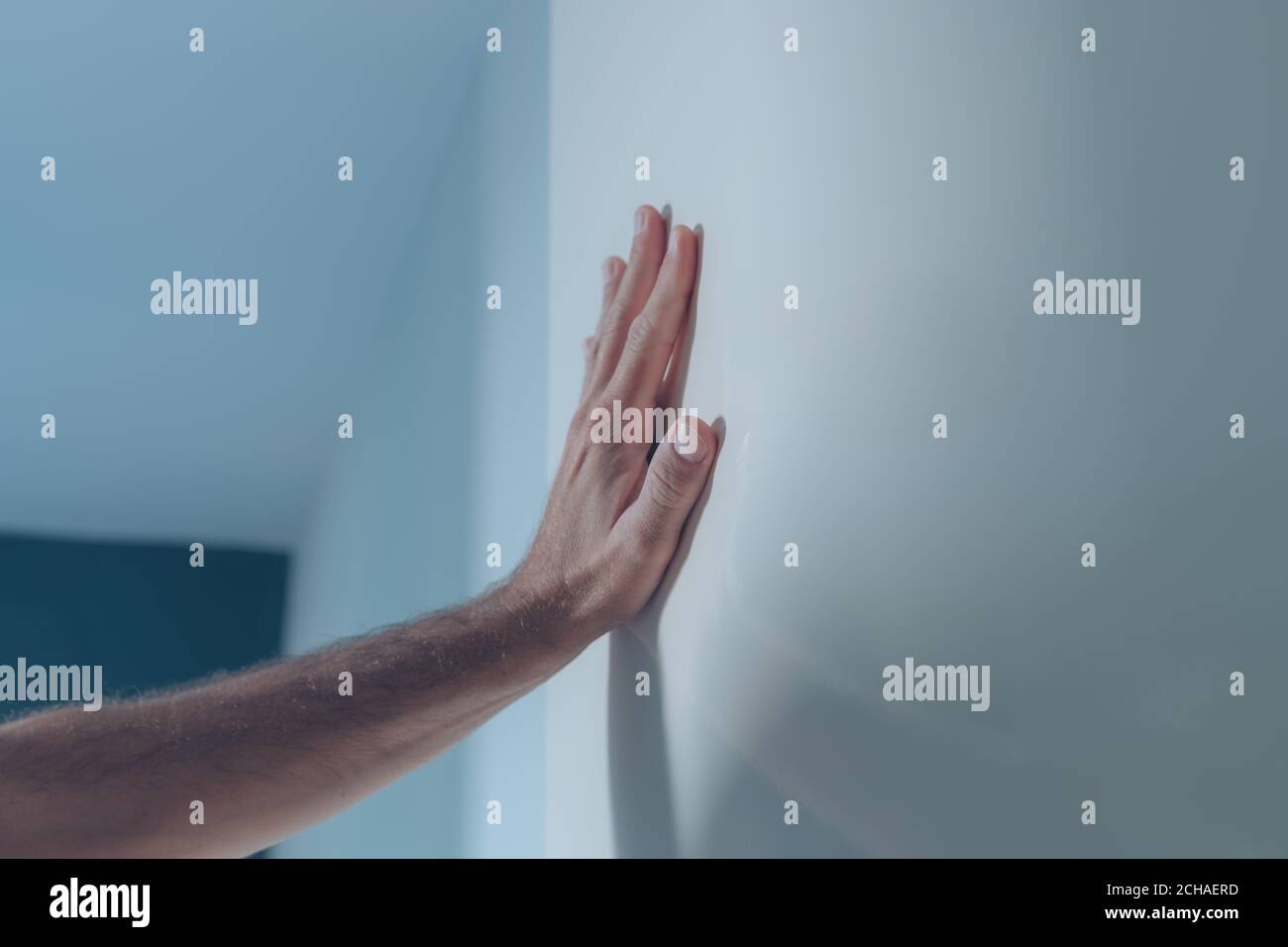 Main masculine penchée sur la porte intérieure blanche, gros plan avec mise au point sélective Banque D'Images