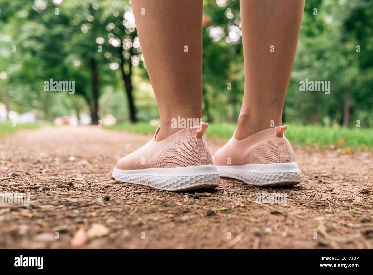 Jogging féminin se préparant à courir le long de la voie dans le parc, gros plan des jambes et des chaussures avec une attention sélective Banque D'Images