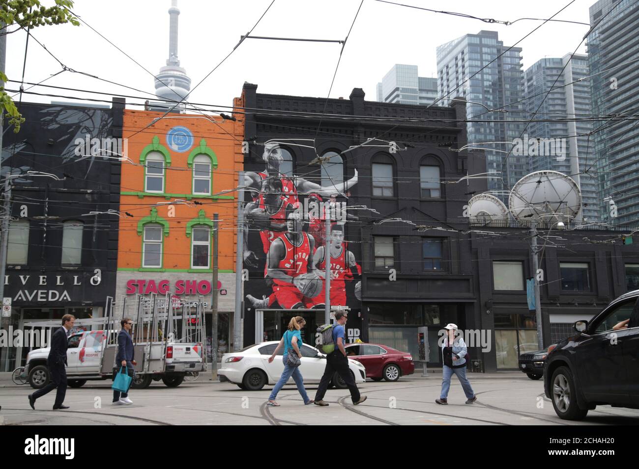 Les gens traversent la rue près d'une fresque représentant les joueurs des  Raptors de Toronto, avant la première finale de la NBA, match de  basket-ball contre les Golden State Warriors à Toronto,