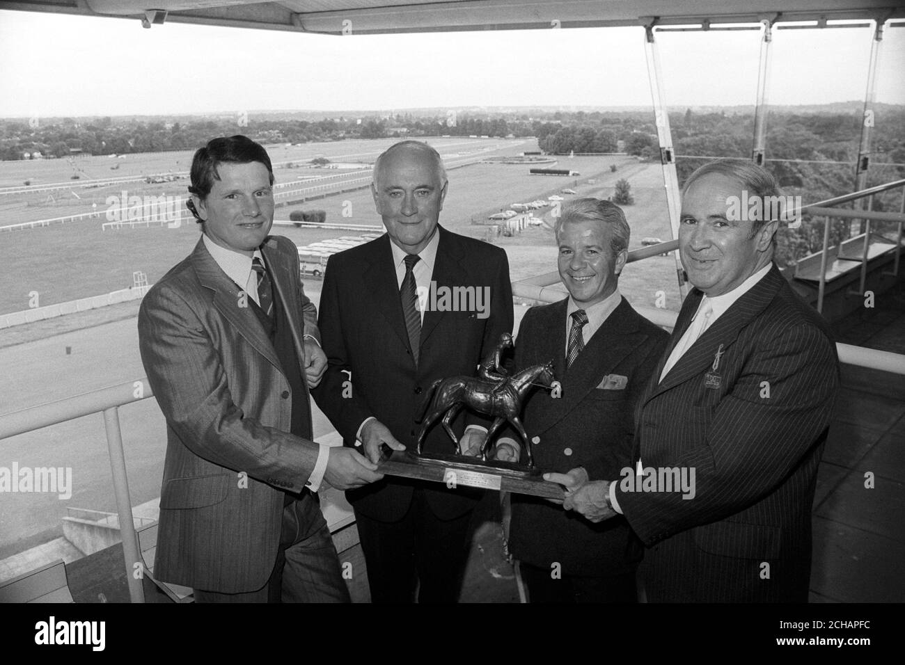 Un cadeau de bronze Mill Reef est remis à David 'Dai' Davies (deuxième à gauche), 65 ans, le reporter en chef des courses de l'Association de la presse, qui prend sa retraite après 39 ans de travail. Aux côtés de Davies, à Sandown Park, se trouvent l'entraîneur de Mill Reef, Ian Balding (l), le jockey Geoff Lewis (deuxième à droite) et David CHIPP (tout à droite), rédacteur en chef de l'Association de la presse. Banque D'Images