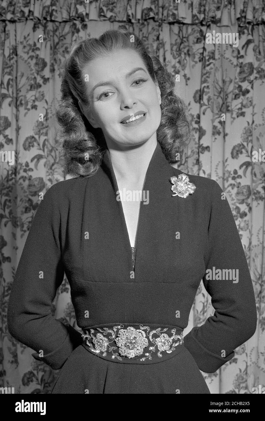 L'actrice britannique Patricia Roc - juste de retour de Paris pour jouer un rôle de premier plan dans le nouveau film "Something Money CAn't Buy" - affiche les accessoires vestimentaires achetés dans la capitale française. Elles comprennent une broche en feuilles d'or décorée de diamants et une ceinture en laine brodée à la main, dos en cuir, ornée de perles d'or et de sequins dorés. Banque D'Images