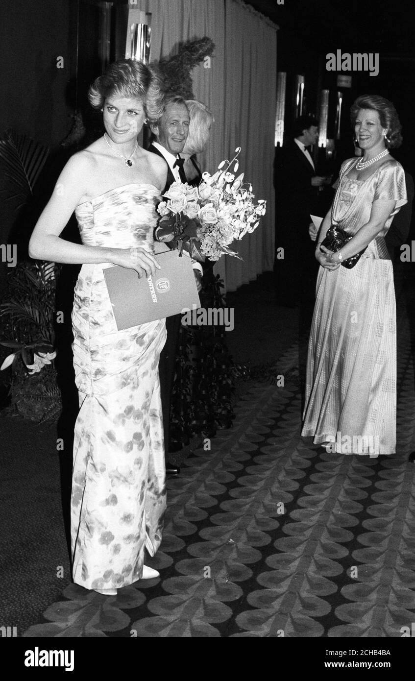 La princesse de Galles porte une robe d'été à l'Empire, Leicester Square, Londres, où, avec le prince Charles, elle assistait à la première caritative de 'Crocodile' Dundee II. En arrière-plan, elle est l'acteur australien Paul Hogan et Linda Kozlowski, qui ont tous deux la vedette dans le film. Banque D'Images