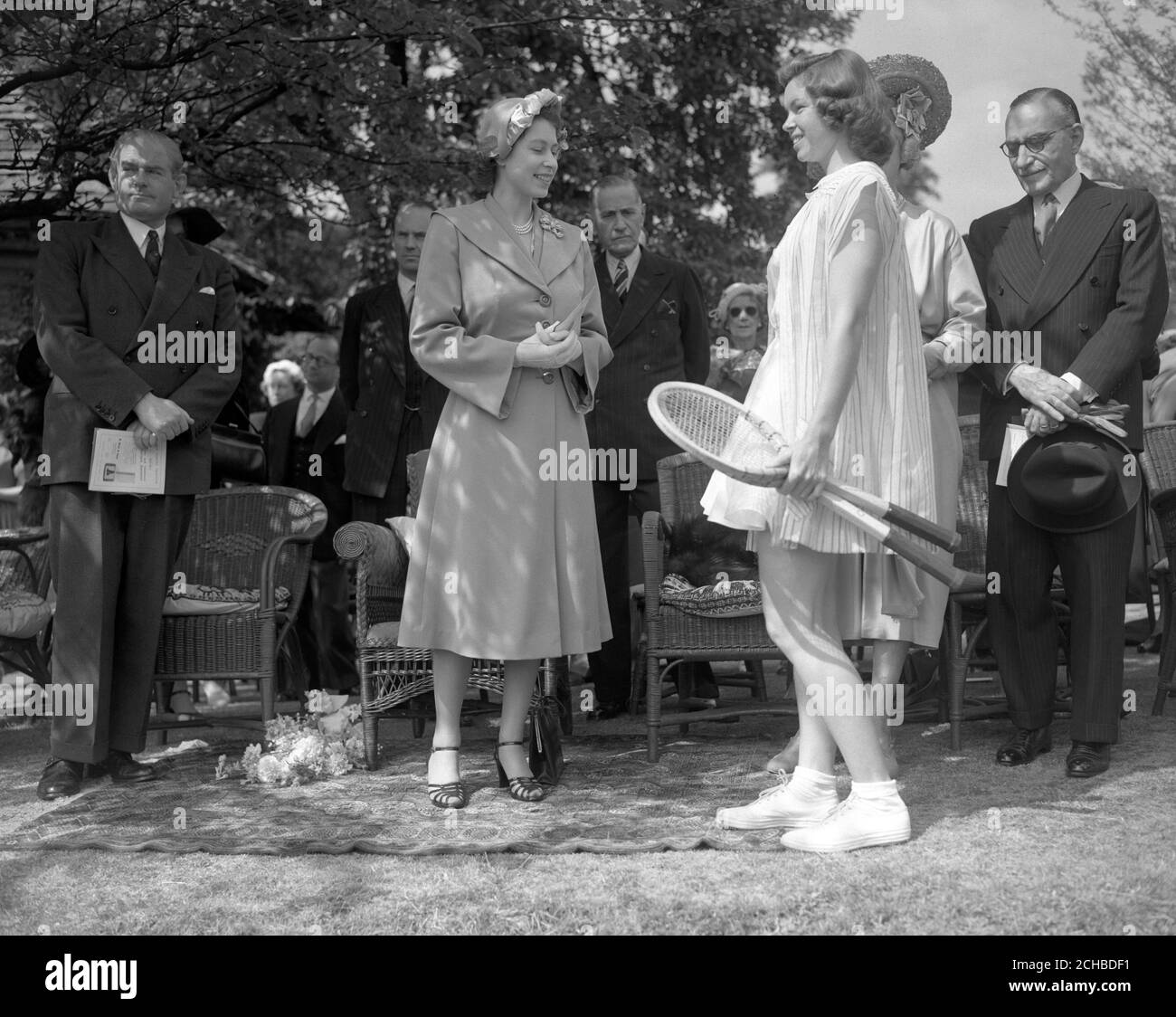 La princesse Elizabeth, en tenue estivale, s'entretient avec la joueuse de tennis américaine Beverly Fleitz lors de la partie de tennis pré-Wimbledon de Lady Crosfield qui s'est tenue chez elle à Highgate, Londres. Le parti a été en faveur du Centre de bien-être des nourrissons de North Islington. Banque D'Images