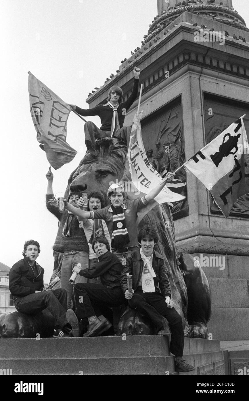 Les supporters de Manchester United grimpent sur un lion Trafalgar Square, avant le match de leur équipe contre Arsenal lors de la finale de la coupe FA. Banque D'Images