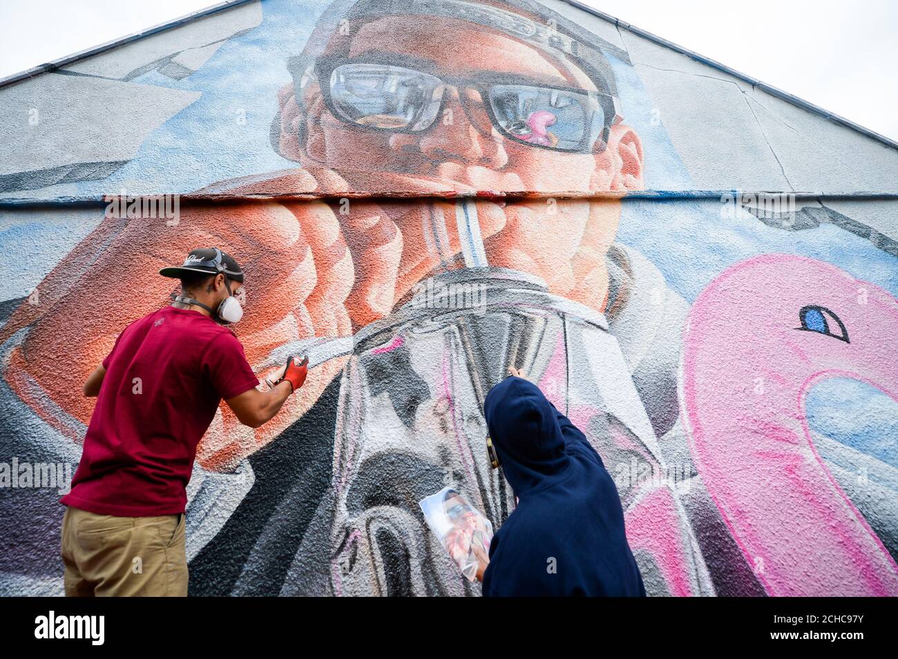 Graffiti artistes 'Fanakapan' (gauche) et 'Insane5' travailler sur une immense fresque sur une maison qu'ils prennent part à un Upfest, street art et graffiti festival à Bristol. Banque D'Images