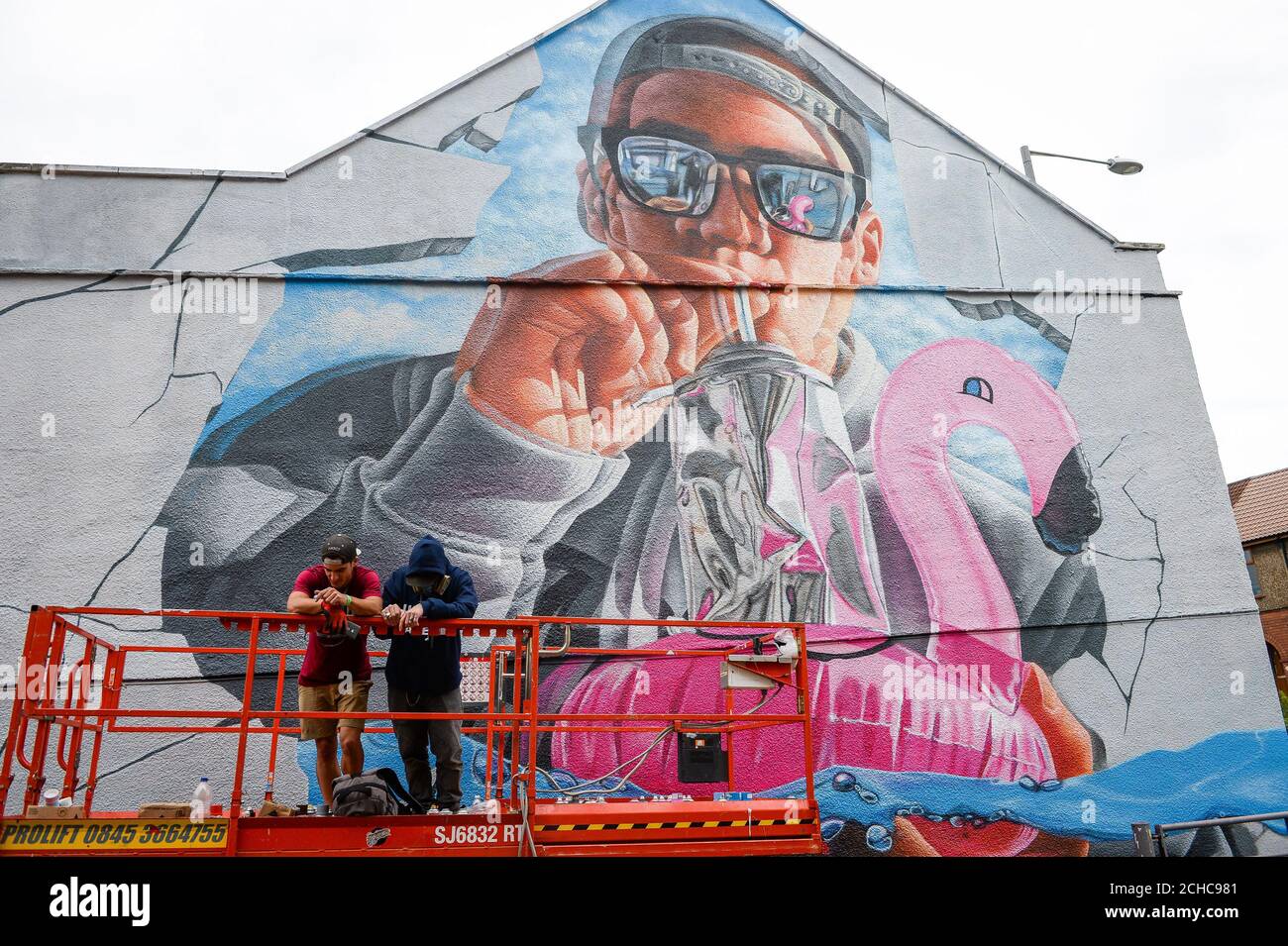 Graffiti artistes 'Fanakapan' (gauche) et 'Insane5' prendre une pause alors qu'ils travaillent sur une immense fresque sur une maison dans le cadre d'un Upfest, street art et graffiti festival à Bristol. Banque D'Images